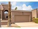 Close up of a large two car brown garage door with address numbers and desert landscaping at 25238 S Mohawk Dr, Sun Lakes, AZ 85248