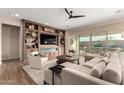 Inviting living room featuring a custom entertainment center with fireplace and patio access at 26999 W Ponderosa Ln, Buckeye, AZ 85396