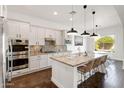 Gourmet kitchen featuring granite countertops, stainless steel appliances, pendant lighting, and a large kitchen island at 2896 E Maplewood St, Gilbert, AZ 85297