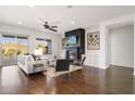 Open-concept living room with a fireplace, hardwood floors, modern decor, and ample natural light at 2896 E Maplewood St, Gilbert, AZ 85297