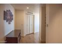Hallway featuring hardwood floors, white walls with art and a dark wood cabinet for storage at 310 S 4Th St # 901, Phoenix, AZ 85004