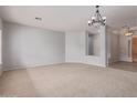 Bright living room with neutral carpet, elegant chandelier, and open layout leading to other rooms at 4522 S Wildflower Pl, Chandler, AZ 85248