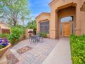 Paver patio featuring outdoor seating, lush landscaping, and views of the entry door at 4582 S Wildflower Pl, Chandler, AZ 85248