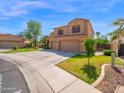 Two-story home featuring a three-car garage, concrete driveway, and well-maintained lawn at 4582 S Wildflower Pl, Chandler, AZ 85248