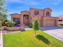 Two-story home with three car garage, seating area, terracotta roof, and manicured lawn at 4582 S Wildflower Pl, Chandler, AZ 85248