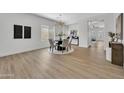 Bright dining room with wood floors, modern chandelier, and seating for four at 5222 W El Cortez Trl, Phoenix, AZ 85083