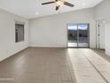 Bright living room featuring wood look flooring and sliding door to the backyard at 7215 N 123Rd Dr, Glendale, AZ 85307