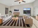 Bright living room with vaulted ceiling, tile floors, neutral walls, and modern furnishings at 7215 N 123Rd Dr, Glendale, AZ 85307