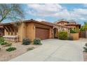 Charming exterior showcasing a well-maintained lawn, a private garage, and a stone archway entry at 7216 E Aurora --, Scottsdale, AZ 85266