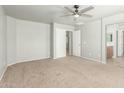 Spacious main bedroom with neutral carpet, a ceiling fan, and an en-suite bathroom for ultimate relaxation at 7622 S 69Th Dr, Laveen, AZ 85339