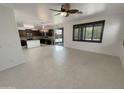 Bright living area with tile floors, a ceiling fan, and an adjacent kitchen with a central island at 7924 S 70Th Ln, Laveen, AZ 85339