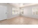 Bright living room featuring tile floors, plantation shutters, and fresh paint at 901 S Storment Ln, Gilbert, AZ 85296