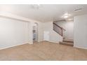 Spacious living room with tile flooring, a staircase, and an arched doorway to the laundry room at 901 S Storment Ln, Gilbert, AZ 85296