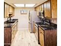 Galley kitchen featuring wood cabinets, stainless steel appliances, and granite countertops at 9735 W Ironwood Dr # A, Peoria, AZ 85345