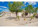 Charming single-story home with a well-maintained desert yard and a two car garage at 10064 E Kilarea Ave, Mesa, AZ 85209