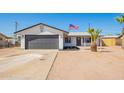 Attractive home with a gray garage door and a well-maintained yard, complemented by an American flag at 1012 E Estevan Ave, Apache Junction, AZ 85119