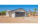 Lovely home featuring a gray garage door, low-maintenance landscaping, and clear blue skies above at 1012 E Estevan Ave, Apache Junction, AZ 85119