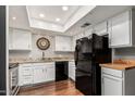 Clean kitchen with white cabinets, granite countertops, modern appliances, and wood-look flooring at 1211 N Miller Rd # 213, Scottsdale, AZ 85257