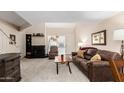 Inviting living room with plush brown sofa, fireplace, and lots of natural light at 1211 N Miller Rd # 213, Scottsdale, AZ 85257