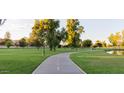 Picturesque park featuring a paved path, grassy areas, mature trees and a tranquil pond for outdoor recreation at 1211 N Miller Rd # 213, Scottsdale, AZ 85257
