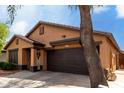 Inviting single-story home with a two-car garage, neutral siding and well-kept landscaping at 12427 W El Nido Ln, Litchfield Park, AZ 85340