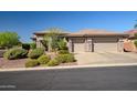 Well-manicured front yard showcasing desert landscaping, a three-car garage and neutral tones at 1557 W Laurel Greens Ct, Anthem, AZ 85086