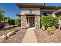 Inviting front entrance framed by stone pillars and desert landscaping with a neutral-colored facade at 1557 W Laurel Greens Ct, Anthem, AZ 85086