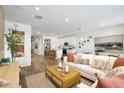 Bright and open living room with hardwood floors and a view into the modern kitchen at 18066 W Sand Hills Dr, Surprise, AZ 85387