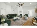 Inviting living room with green sofas, chairs, light-colored walls, and wood floors at 1918 E Anchor Dr, Gilbert, AZ 85234