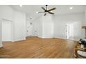 Bright living room with light wood floors, white walls, and ceiling fan at 1918 E Anchor Dr, Gilbert, AZ 85234