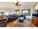 Spacious living room with wood floors, large windows, and comfortable seating, perfect for relaxation at 20183 N Big Dipper Dr, Maricopa, AZ 85138