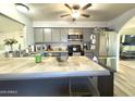 Bright kitchen featuring gray cabinetry, stainless steel appliances, and spacious tile countertop island at 2329 E Juanita Ave, Mesa, AZ 85204