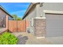 Side view of home featuring gray exterior and a wooden fence gate at 27173 N 86Th Ave, Peoria, AZ 85383