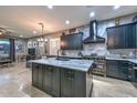 Modern kitchen boasts sleek black cabinets, stainless steel appliances, and a large central island at 27173 N 86Th Ave, Peoria, AZ 85383