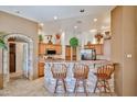 Inviting kitchen with a stone-clad breakfast bar, tile flooring, wooden cabinets and stainless steel appliances at 2862 N 156Th Dr, Goodyear, AZ 85395