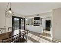 Bright kitchen and dining area with black French doors, white cabinets and countertops, and stainless-steel appliances at 3324 S Juniper St, Tempe, AZ 85282