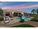 Inviting backyard pool with a fire pit, mature landscaping, and patio with overhead lighting at 4817 E Cielo Grande Ave, Phoenix, AZ 85054