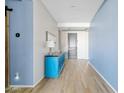 Bright entryway featuring a sleek blue cabinet, neutral walls, and modern lighting fixtures; adjacent to the front door at 5320 W Fawn Dr, Laveen, AZ 85339