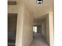 Unfinished hallway featuring textured walls and doorway to another room at 5551 S 240Th Ln, Buckeye, AZ 85326