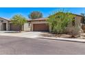 Street view of a single-story home with desert landscaping, a tile roof, and a two-car garage at 6413 S 47Th Dr, Laveen, AZ 85339
