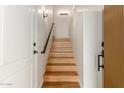 Bright staircase featuring modern lighting fixtures, black iron handrail, and a light wood finish at 705 W Queen Creek Rd # 2078, Chandler, AZ 85248