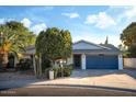 Single story home featuring a large driveway and a two car garage with desert landscaping at 7412 S Elm St, Tempe, AZ 85283