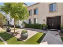 Welcoming front entrance showcasing a well-maintained lawn, brick accents, and lush greenery at 7694 E Minnezona Ave, Scottsdale, AZ 85251