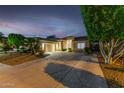 Twilight view of home, showcasing the extended driveway and garage at 9908 E Medina Ave, Mesa, AZ 85209