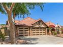 Charming home boasts a clay tile roof, brick accents, and convenient three-car garage at 1114 W Meseto Ave, Mesa, AZ 85210