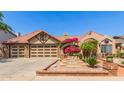 Charming home boasts a clay tile roof, brick accents, inviting courtyard, and convenient three-car garage at 1114 W Meseto Ave, Mesa, AZ 85210