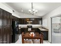 Cozy kitchen featuring dark cabinetry, granite countertops, and a dining area at 11925 N 67Th Dr, Peoria, AZ 85345