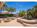 Backyard patio featuring a cozy fire pit, seating, and a luxurious hot tub at 12749 E Poinsettia Dr, Scottsdale, AZ 85259