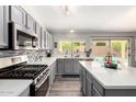 Modern kitchen featuring stainless steel appliances, gray cabinets, and quartz countertops at 1425 E Darrel Rd, Phoenix, AZ 85042