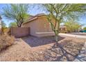 Home exterior featuring a block wall, desert landscaping, and an exterior utility access at 1524 N Milly Pl, Casa Grande, AZ 85122